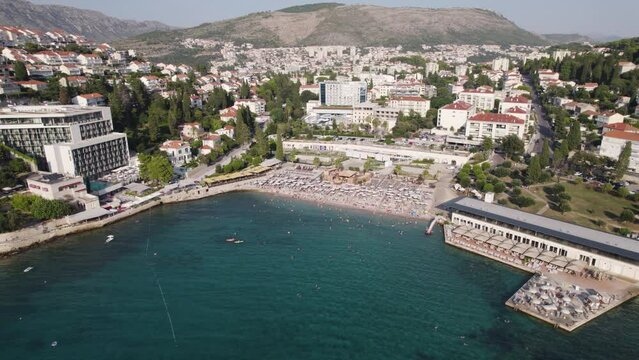 Uvala Lapad beach packed with visitors sunbathing in Dubrovnik Croatia, aerial
