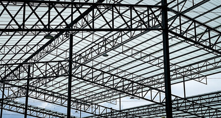 Steel frame and beam structural elements for the new building contrast with the blue sky from a low...