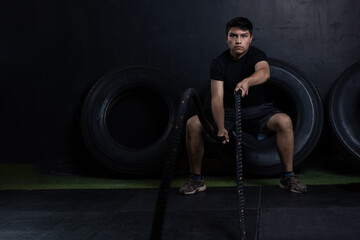 Young mexican man with ropes exercising physically at cross fit gym