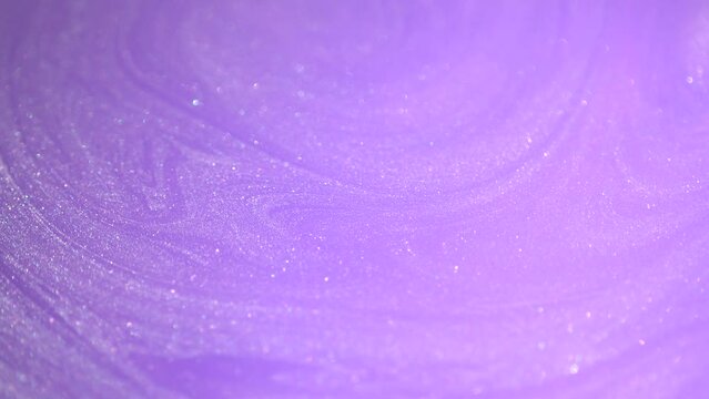 Pastel lilac, lavender, purple pearl colors liquid paint. Ink flow macro. Glitter fluid motion. Beautiful glitter abstract background