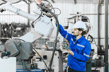 Engineer worker fix service replace broken part of automatic industry robotic welding arm....