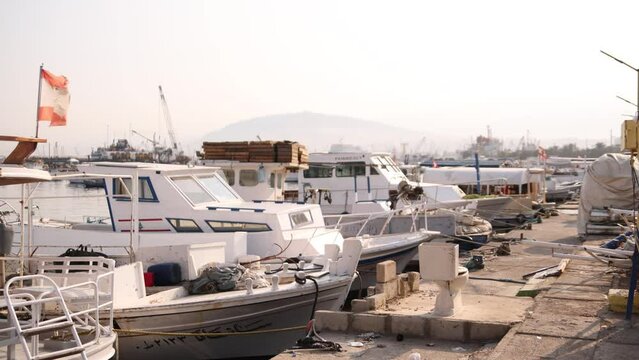 rows of boats and yachts in mediterranean harbor with flag waving in Tripoli, Northern Lebanon