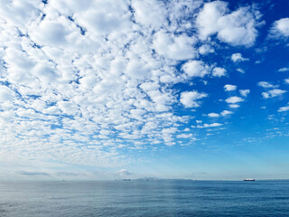 夏の海辺の風景　青空にまだらに浮かぶふわふわの雲模様