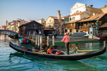 A gondolier working in Venice - obrazy, fototapety, plakaty