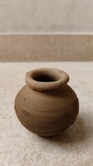 a container pot called as Matka is made from clay and the pottery is made by a child. this pot is a...