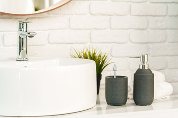 Bathroom interior with circle shaped mirror in wooden frame and white sink