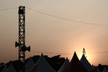 Sunset view of event venue with pyramid tent and toa loudspeaker on pole