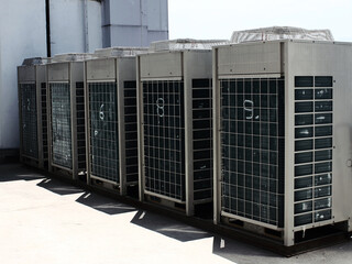 Industrial air conditioner condensers outside unit on the roof of a building on a hot summer day