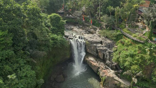 Rotating drone view over waterfall in rainforest jungle in Bali. Sunny day
