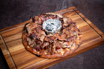 Turkish Iskender Shawarma Meat or beef or chicken with Charcoal in the center and sauces around. Cook fries grilled meat shawarma. Hot fresh delicious kebabs - a fine selection of street food.