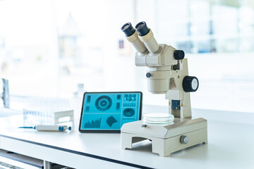 Microscope and tablet screen in the laboratory.