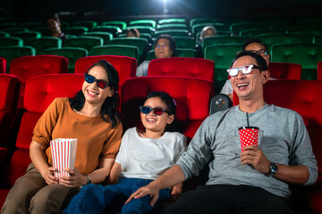 Naklejka premium Asian family relax and fun togather by watching 3d action cinema in theater