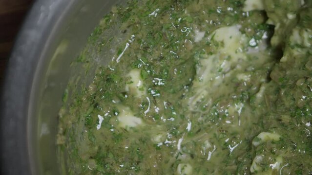 Preparation of a delicious herb butter. The cook mixes the ingredients. Close-up.