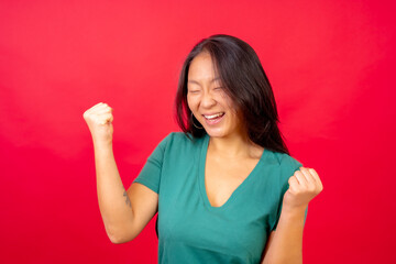 Chinese woman celebrating raising fist with eyes closed