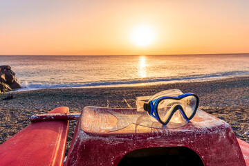 beautiful cloudy morning landscape with diving mask on a red old boat on foreground, sand beach,...
