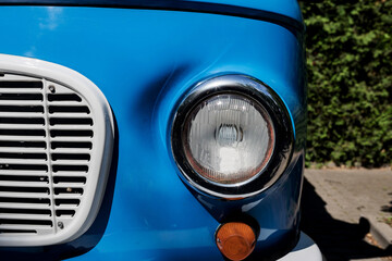 the headlight of a blue retro car.