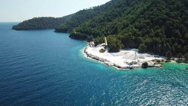 Marble  quarry exploitation in Porto Vathy , Thassos Island , Greece , on the shore of the Aegean sea , industrial installation for marble processing , aerial drone footage