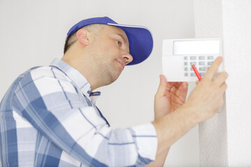 hvac technician installing faceplate on a digital thermostat