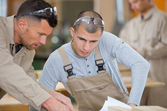 workman and apprentice looking at plans