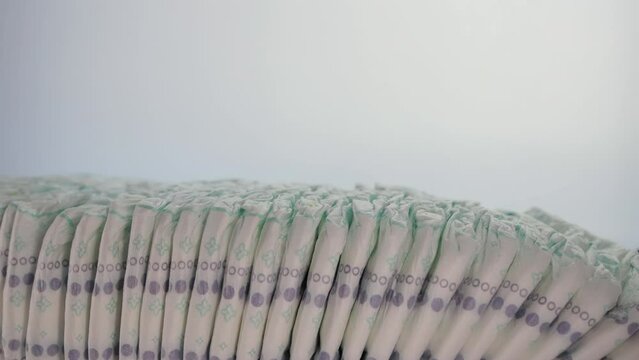 Lots of baby cotton diapers on a white background. The concept of softness, lightness and naturalness. Hypoallergenic, copy space for text. Copy space for text. Slow motion