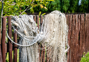 Fishing nets hung on the fence create a picturesque image of the traditional craft of fishing, conveying an atmosphere of calm and mystery at the water's edge