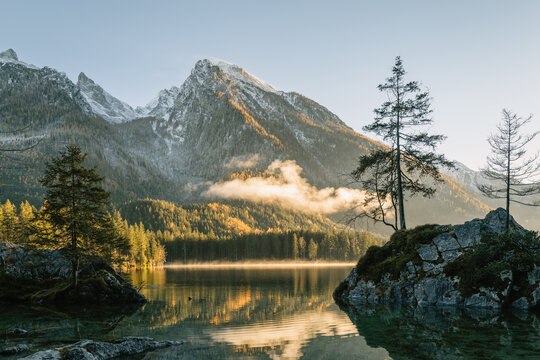kleine Insel auf dem Hintersee bei Sonnenuntergang mit dem verschneiten Hochkalter im Herbst