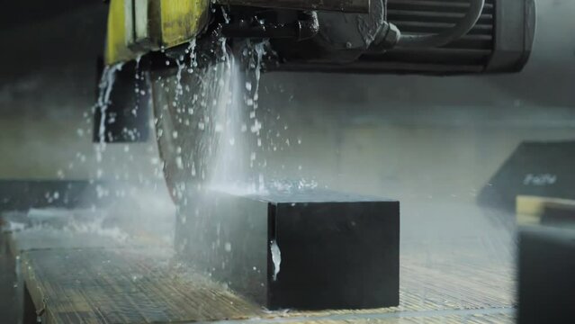 Cutting porcelain stoneware material with a special saw for the manufacture of tiles for finishing facades and tombstones. Production for the production of ceramic plates with digitization. Slow