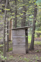 Outdoor toilet in the forest. Wooden building in the park.