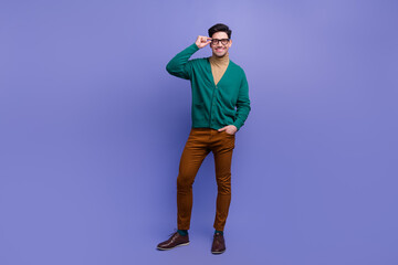 Full length photo of cheerful nice positive man wear trendy green clothes eyewear standing empty space isolated on violet color background
