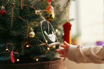 Set of ornaments hanging off a traditional Christmas tree.