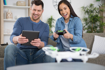 happy couple playing with a small quadrocopter drone
