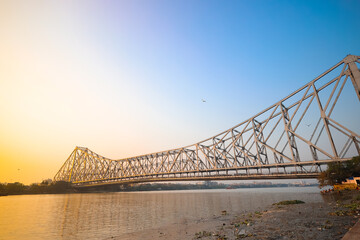 Obraz premium Historic Howrah bridge Kolkata at sunset with blue sky.