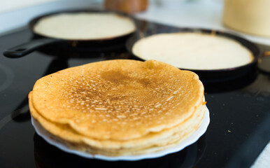 Cooking traditional pancakes from wheat flour in the kitchen
