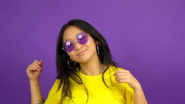 Chinese woman with sunglasses dancing and smiling