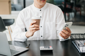 Asian man sitting at a desk using a laptop computer Navigating Finance and Marketing with Technology