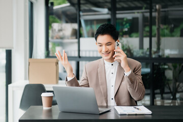  Working man concept a male manager attending video conference and holding tablet, smatrphone in office