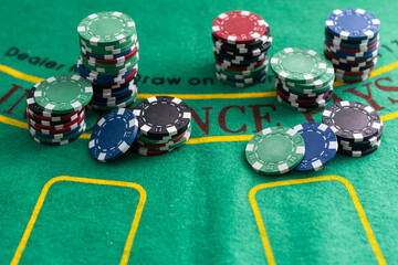 different color chips for gambling and playing cards on green