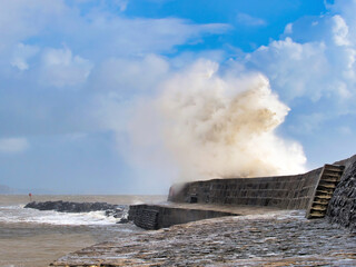 Stormy waves crashing over the Cobb seawall at Lyme Regis at the tail end of Storm Ciarán