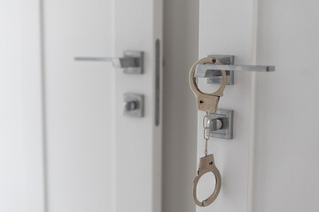 handcuffs on door handle in home background