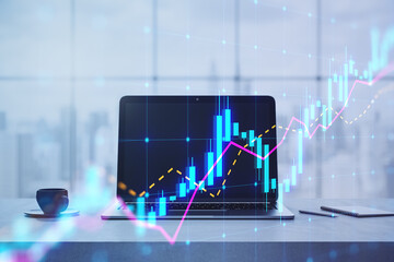 Laptop with glowing stock market graphs in office