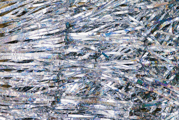 The texture of tinsel is silver. Decorations for Christmas and New Year.