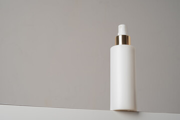 Care cosmetic product in white bottle on a gray background. Copy space