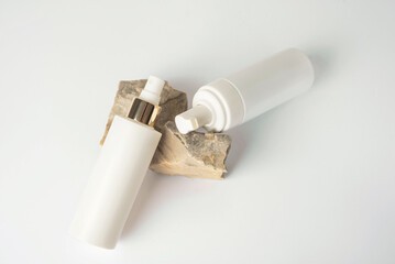Cosmetic care products in white bottles on a stone. Top view. Copy space
