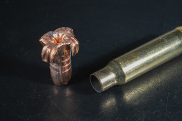 Expansive crumpled 308 caliber bullet and spent cartridge case, close up.