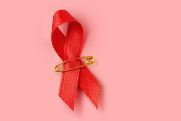Red ribbon on pink background - Concept of violence against women - obrazy, fototapety, plakaty