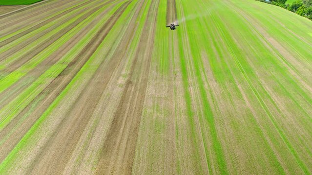 Machines till the fields for the coming harvest year. Wide angle drone shot.