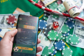 Sports betting website in a mobile phone screen, ball, money