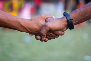Another man shaking hands with a man wearing a black watch