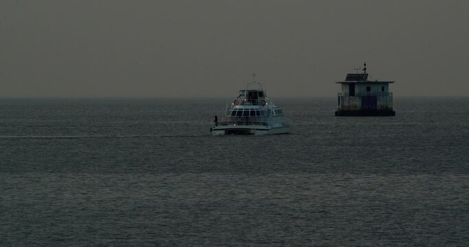 Time lapse of a yacht with an Argentine flag sailing on the water and making a U-turn, cloudy, the sun is setting