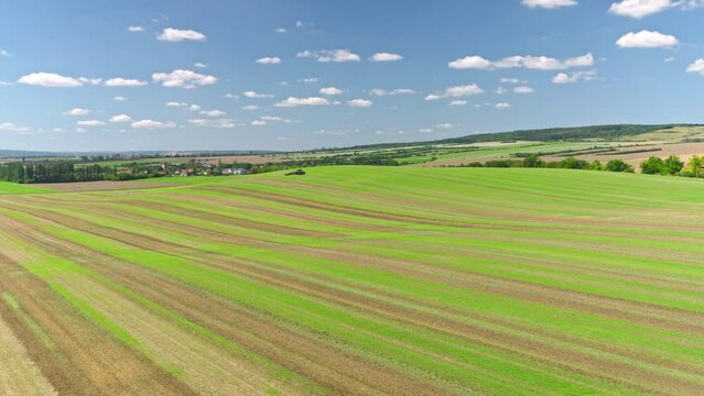 Machines till the fields for the coming harvest year. Wide angle drone shot.